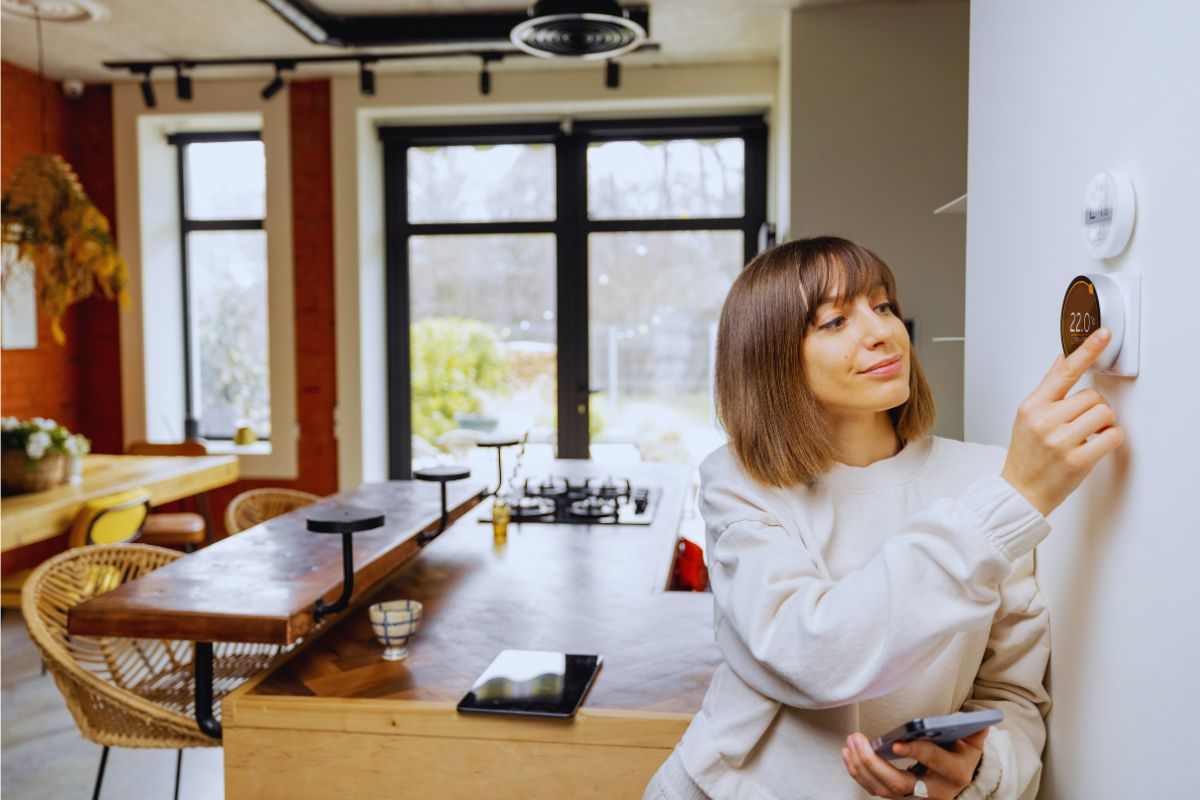 donna che aziona il termostato